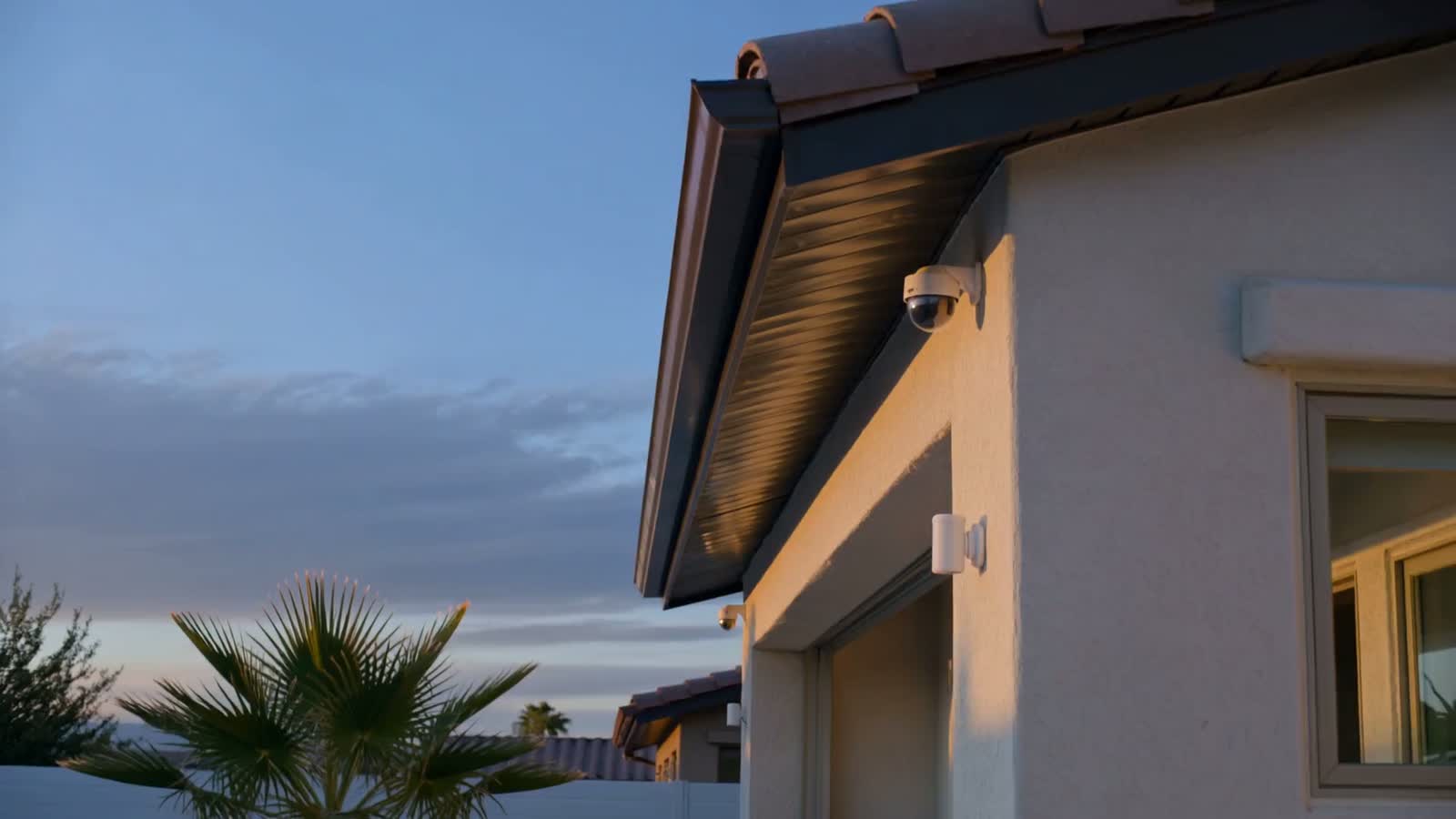 A security camera mounted under the eave of a house